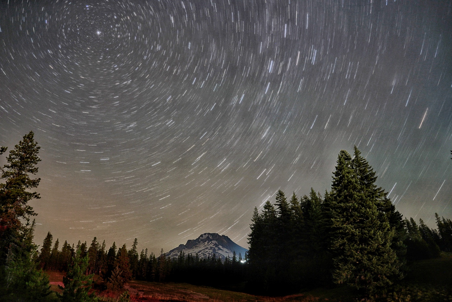 The night sky spins around the North Star above Mt. Hood